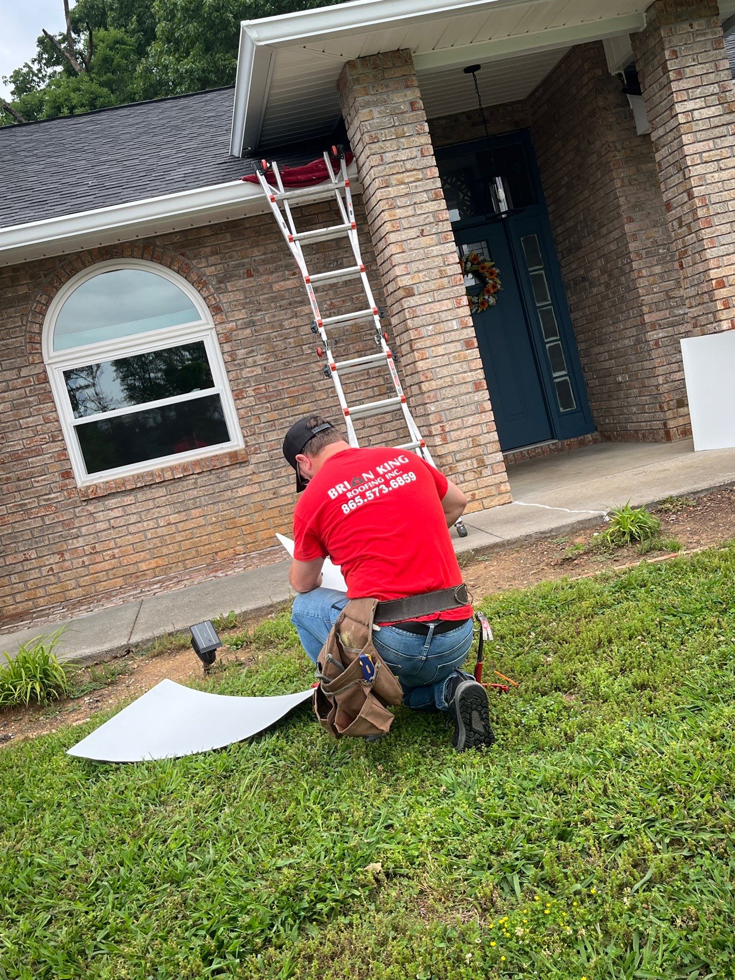 Brian King Roofing representative inspecting a residential roof during a free estimate