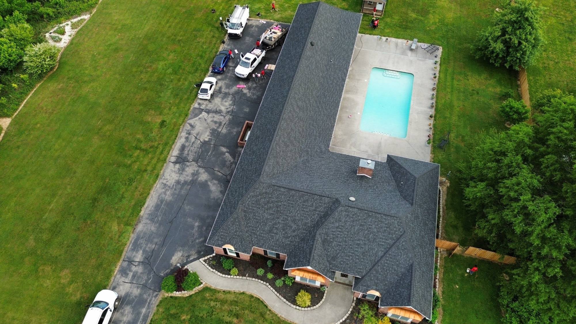 Drone photo of a completed Brian King Roofing residential shingle install — East Tennessee home with driveway and mature landscaping